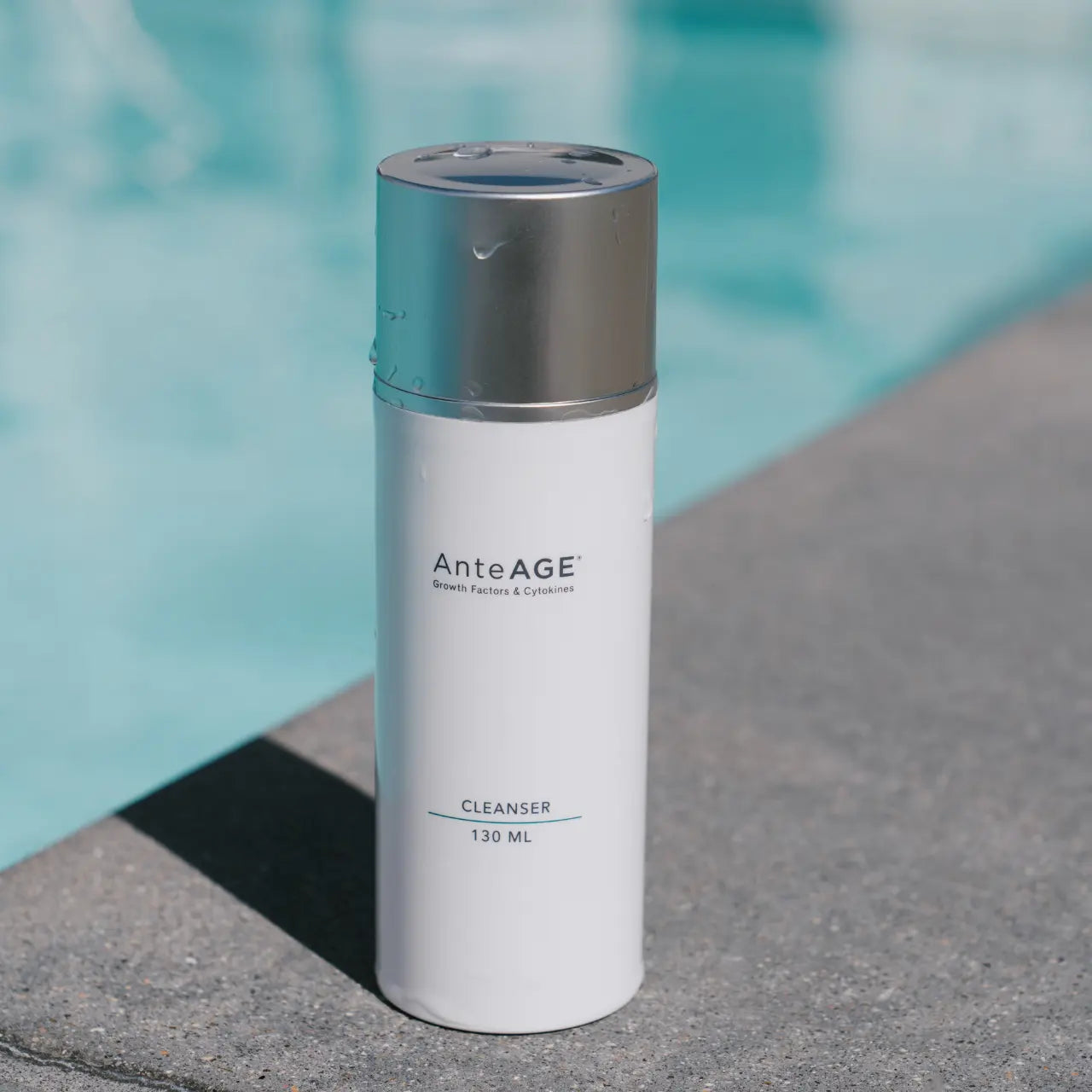 AnteAGEĀ® Cleanser bottle by water, showcasing a gentle, sulfate-free cleanser ideal for all skin types, designed to cleanse impurities while maintaining skin's natural moisture balance.