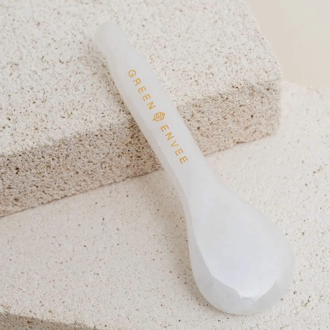 Green Envee White Jade Gua Sha Eye Tool brightens dark circles by promoting circulation and improving skin tone under the eyes.