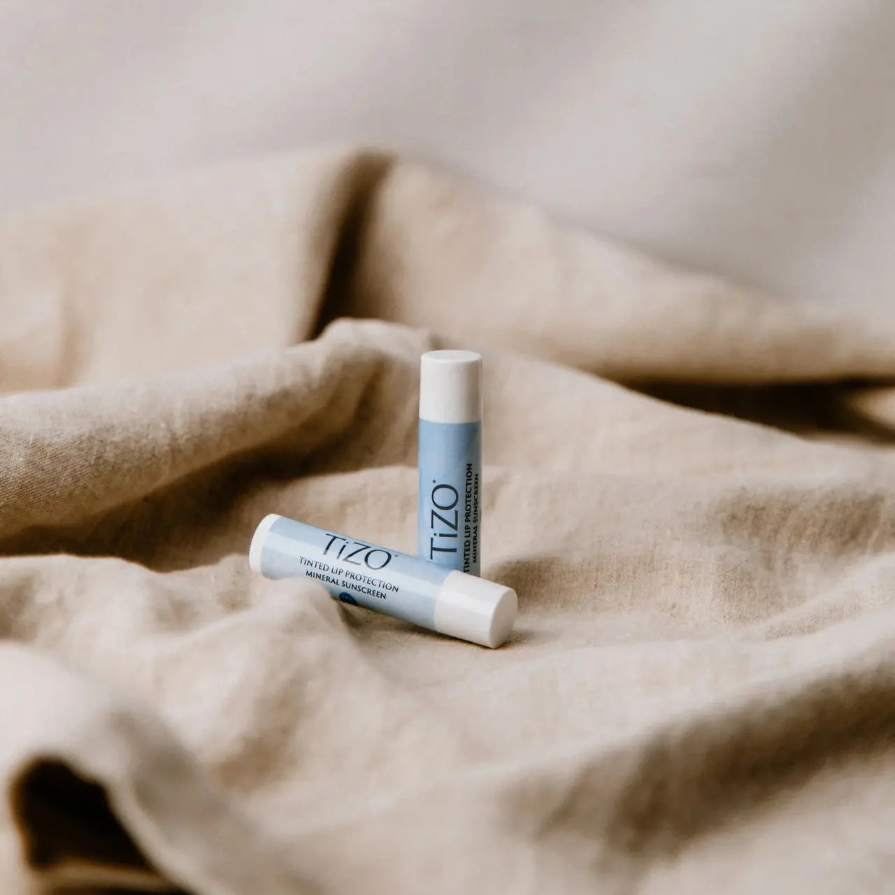 Hydrating tinted lip balm by TIZO® enhances natural lip color while moisturizing sensitive lips with Vitamin E and C.